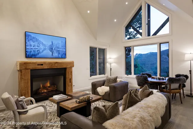 a living room with furniture large window and fireplace