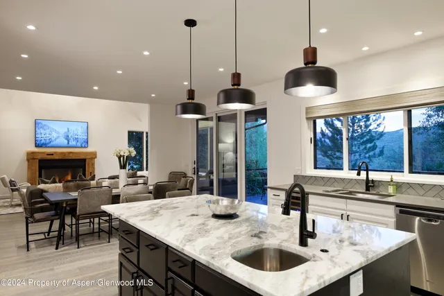 a kitchen with a counter a sink and living room view