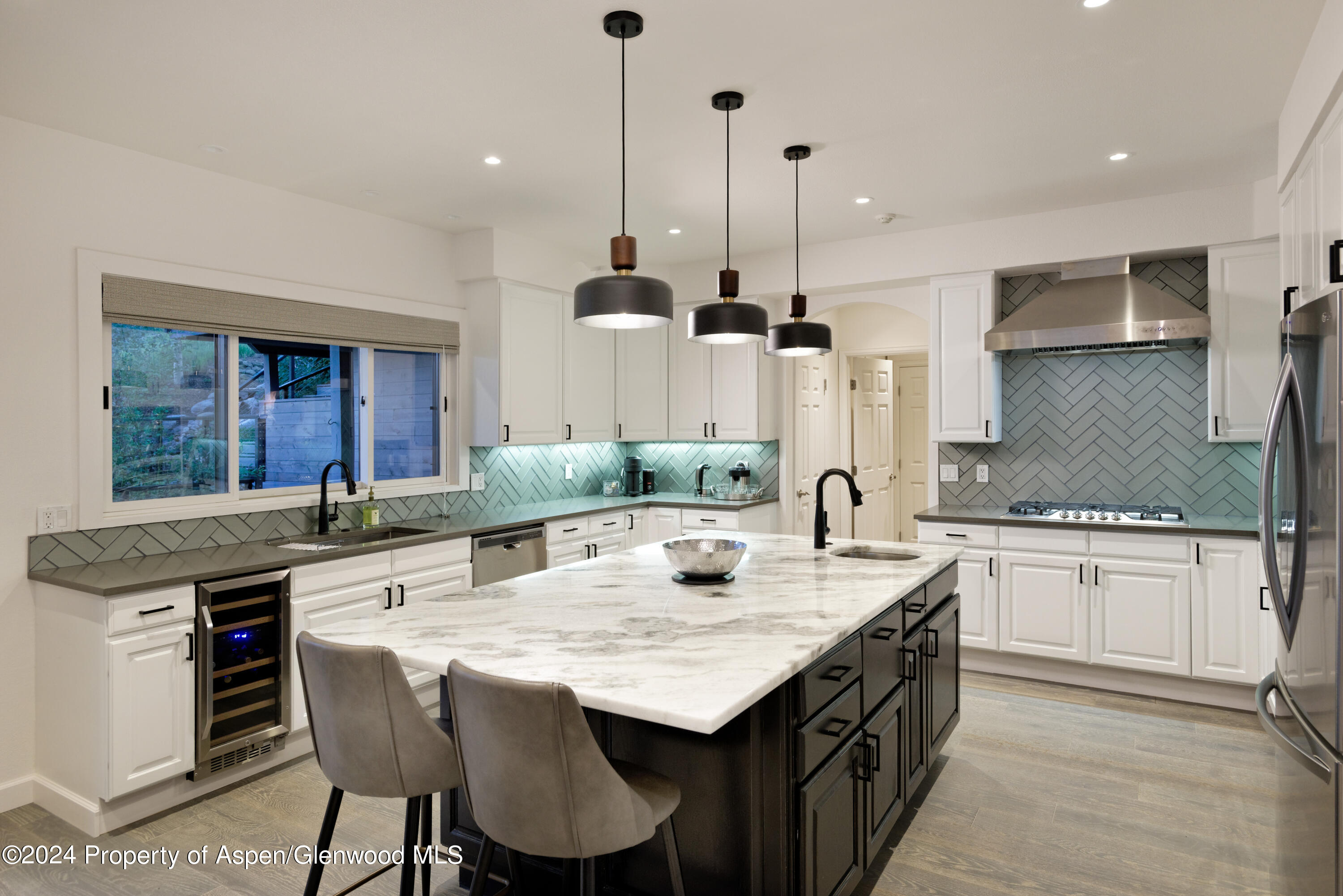 400 Medicine Bow Road Aspen, CO 81611 - Photo 10 of 36 a kitchen with granite countertop a sink a stove and chairs