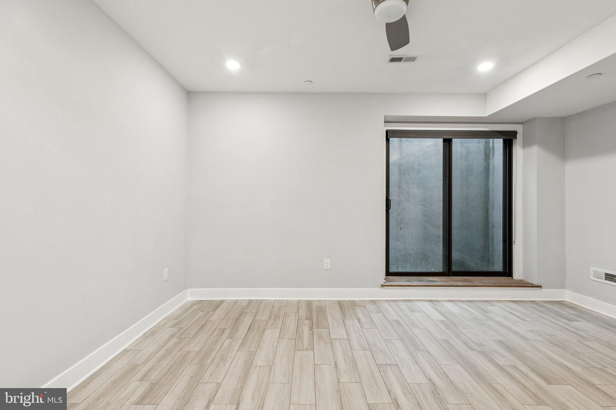 814 North Uber Street, Unit 2 Philadelphia, PA 19130 - Photo 28 of 68 an empty room with wooden floor and windows
