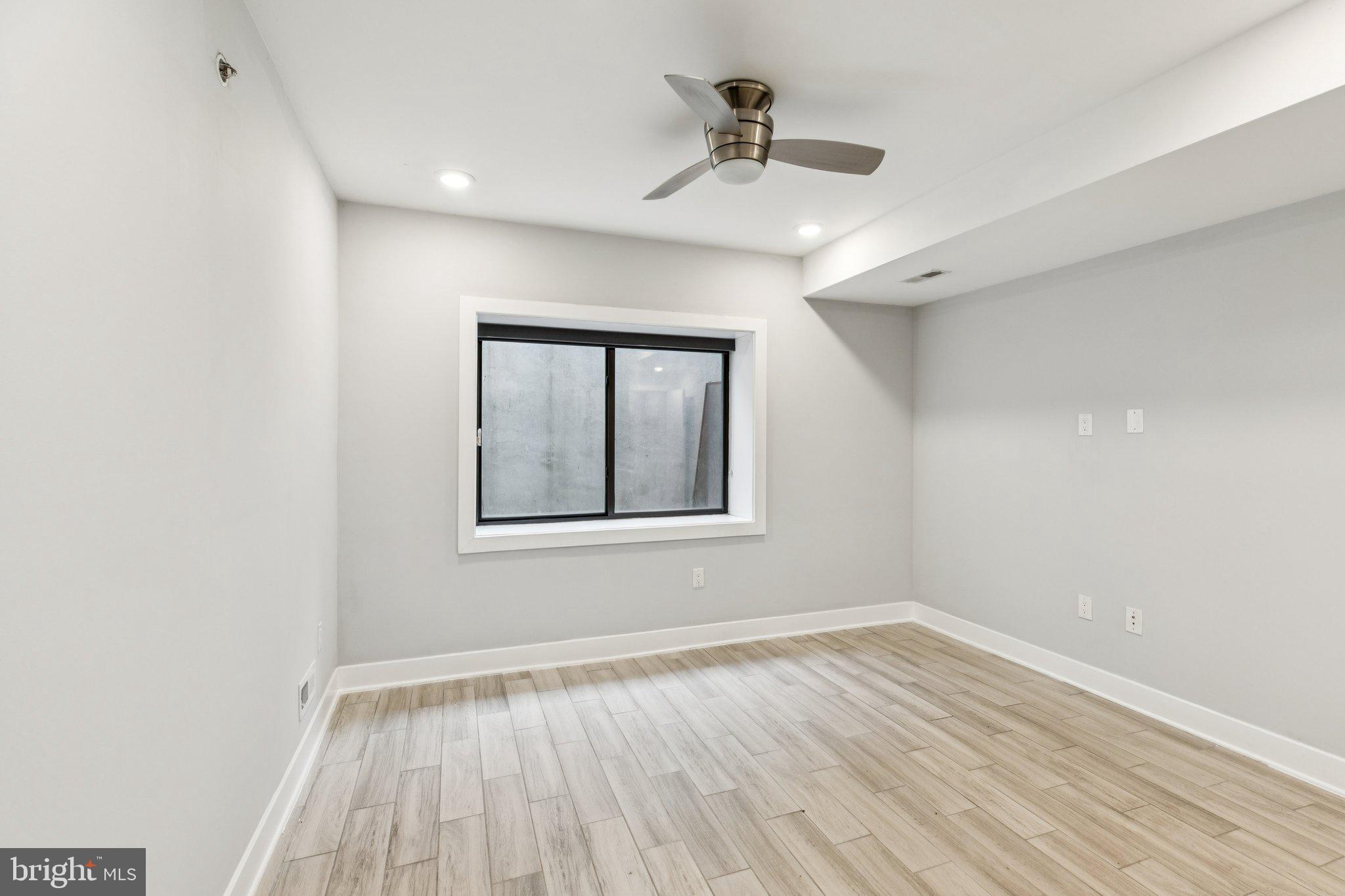 814 North Uber Street, Unit 2 Philadelphia, PA 19130 - Photo 40 of 68 a view of an empty room with a window and wooden floor