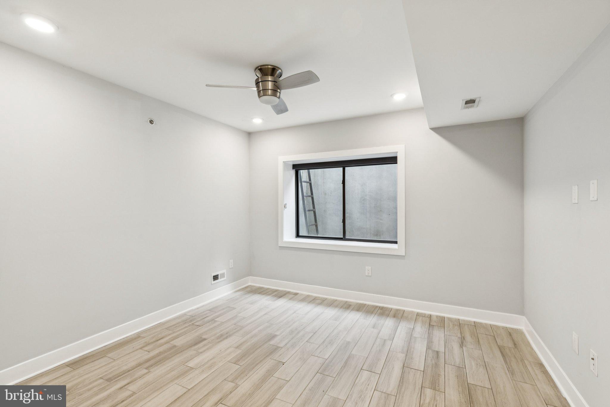 814 North Uber Street, Unit 2 Philadelphia, PA 19130 - Photo 46 of 68 a view of an empty room with wooden floor and a window