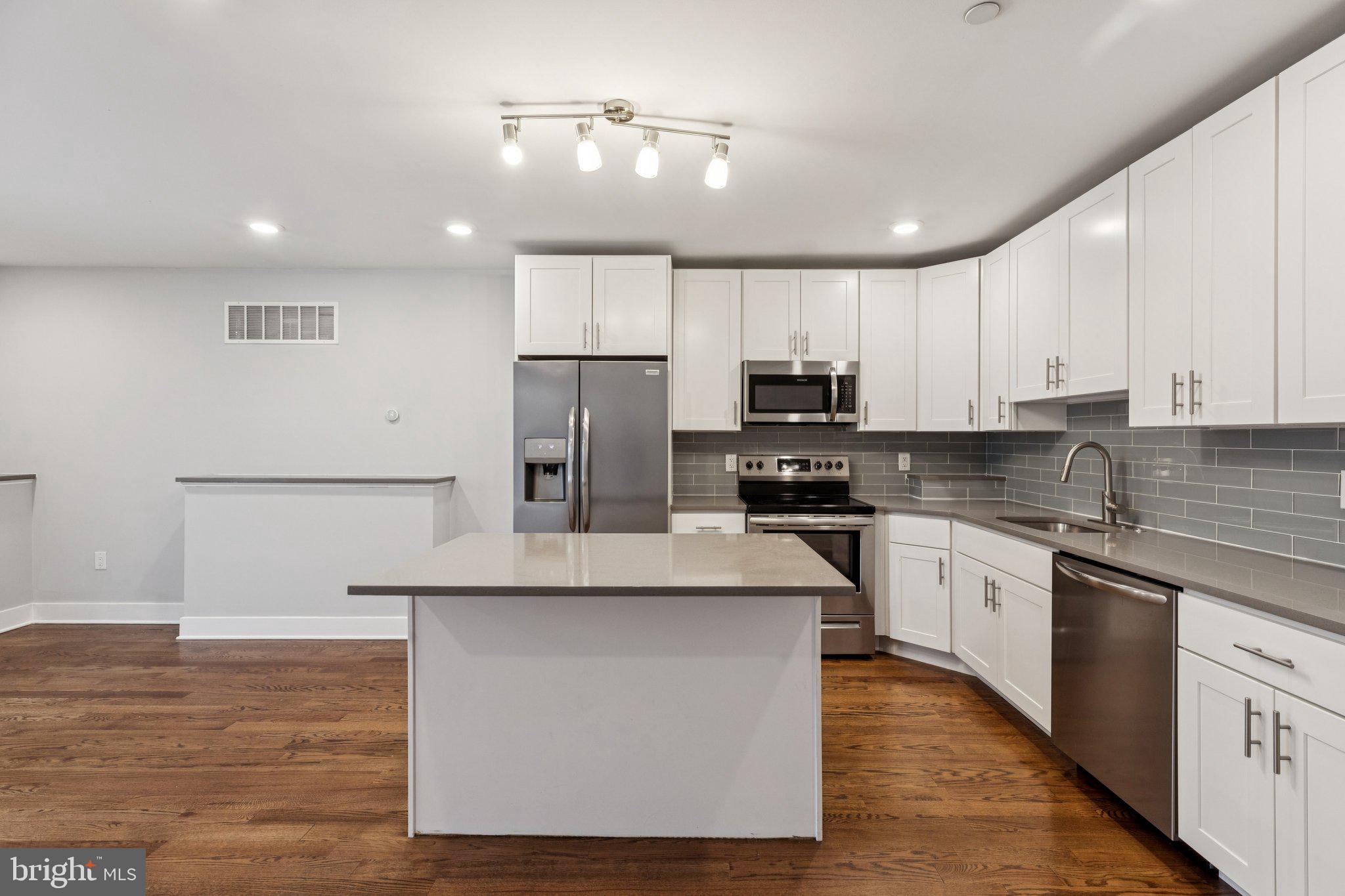 814 North Uber Street, Unit 2 Philadelphia, PA 19130 - Photo 6 of 68 a kitchen with kitchen island granite countertop a stove a sink and a refrigerator