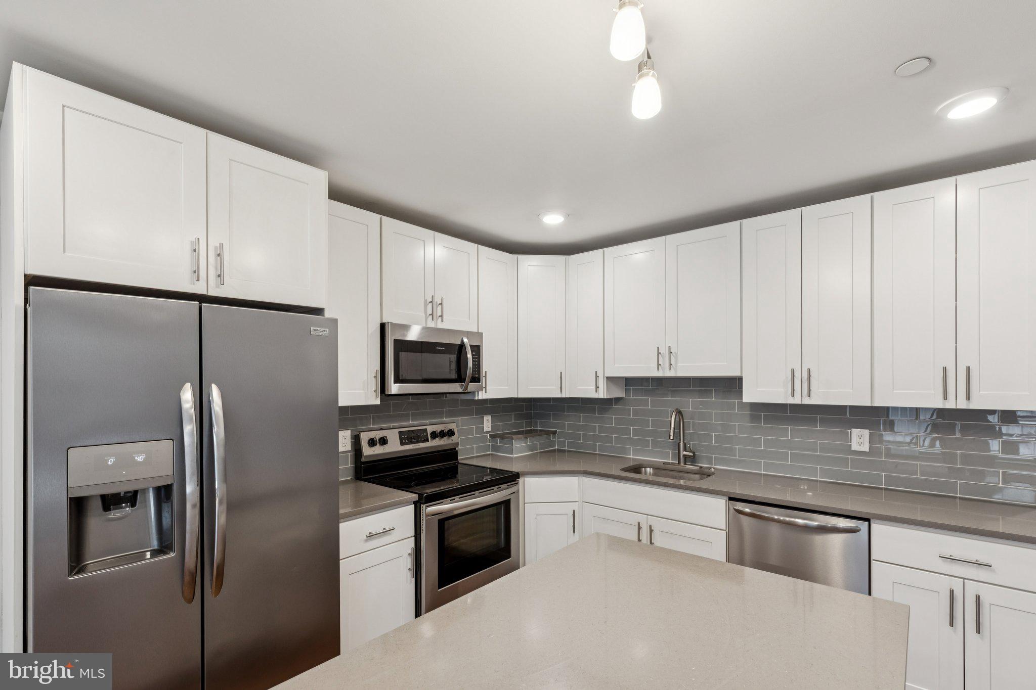 814 North Uber Street, Unit 2 Philadelphia, PA 19130 - Photo 9 of 68 a kitchen with stainless steel appliances granite countertop a refrigerator a stove a sink and white cabinets