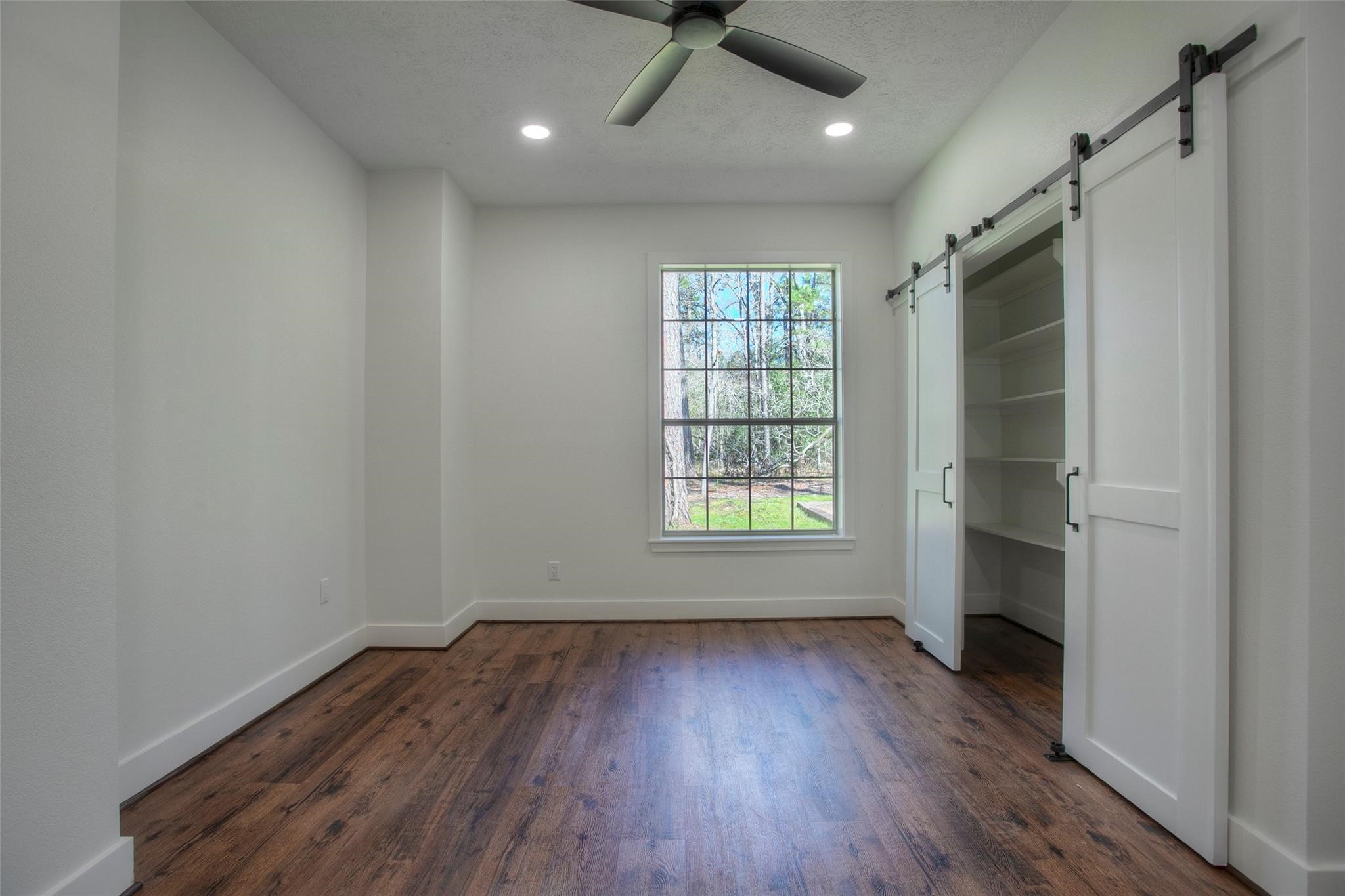 83 Dahlia Road Huntsville, TX 77320 - Photo 29 of 49 an empty room with wooden floor and a window