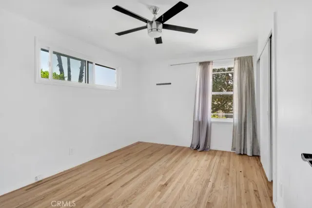 a view of a livingroom with wooden floor and a ceiling fan