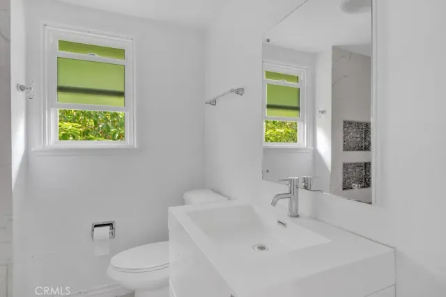 a white toilet sitting next to a bathroom sink