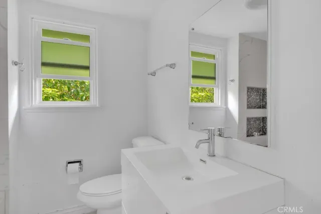 a white toilet sitting next to a bathroom sink