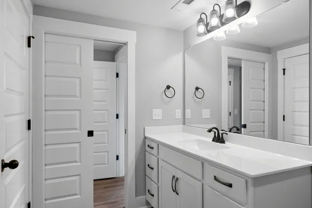 a bathroom with a sink vanity and mirror