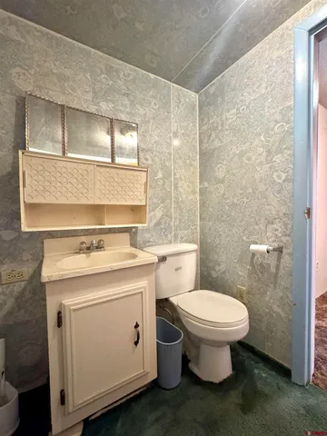 a bathroom with a toilet sink and mirror