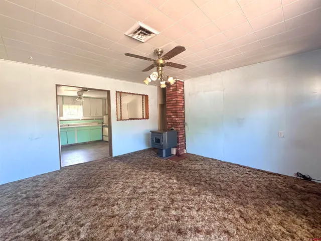 a view of a livingroom with a chandelier fan and a window