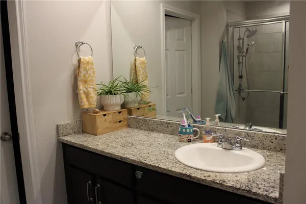 a bathroom with a granite countertop sink and a mirror