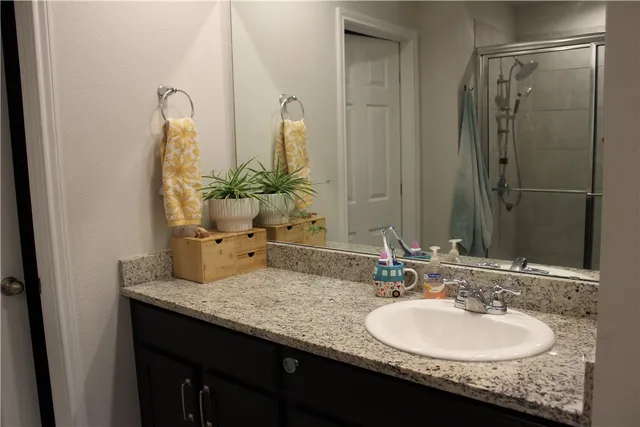 a bathroom with a granite countertop sink and a mirror