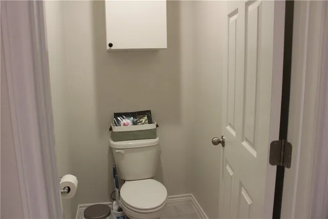 a white toilet sitting next to a shower
