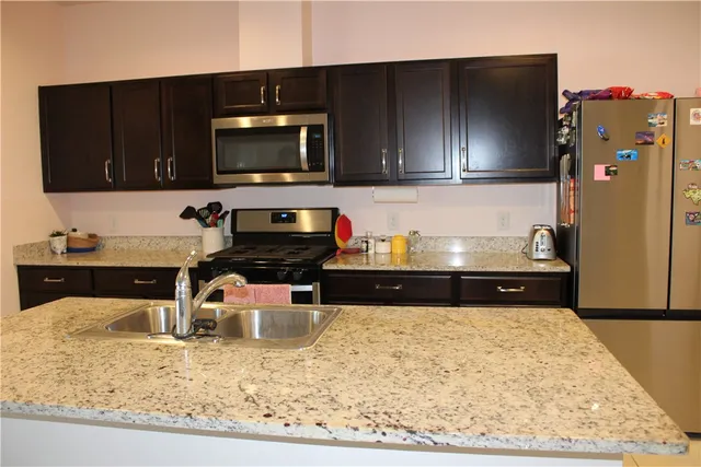 a kitchen with a refrigerator and a stove top oven