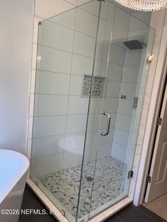 a spacious bathroom with a double vanity sink a large mirror and a bathtub