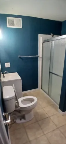 a white toilet sitting next to a shower