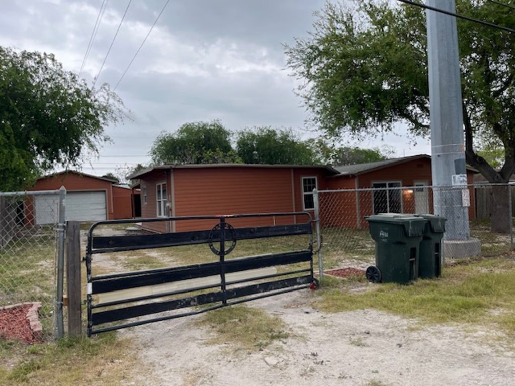 450 Skipper Lane Corpus Christi, TX 78418 - Photo 3 of 26 a backyard of a house with wooden fence and large trees