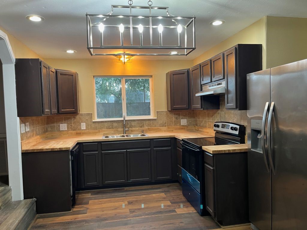 450 Skipper Lane Corpus Christi, TX 78418 - Photo 8 of 26 a kitchen with stainless steel appliances granite countertop a sink stove and refrigerator