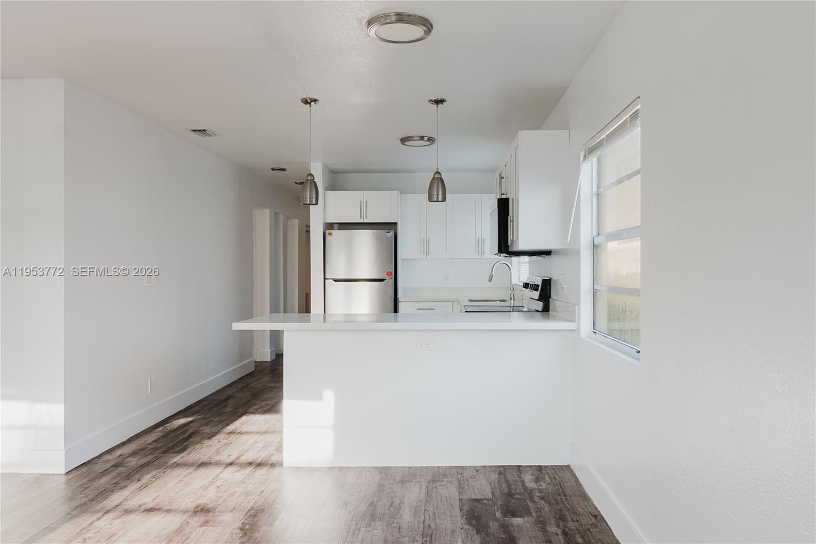 4338 Northwest 24th Avenue Miami, FL 33142 - Photo 4 of 26 a kitchen with stainless steel appliances a sink and a refrigerator
