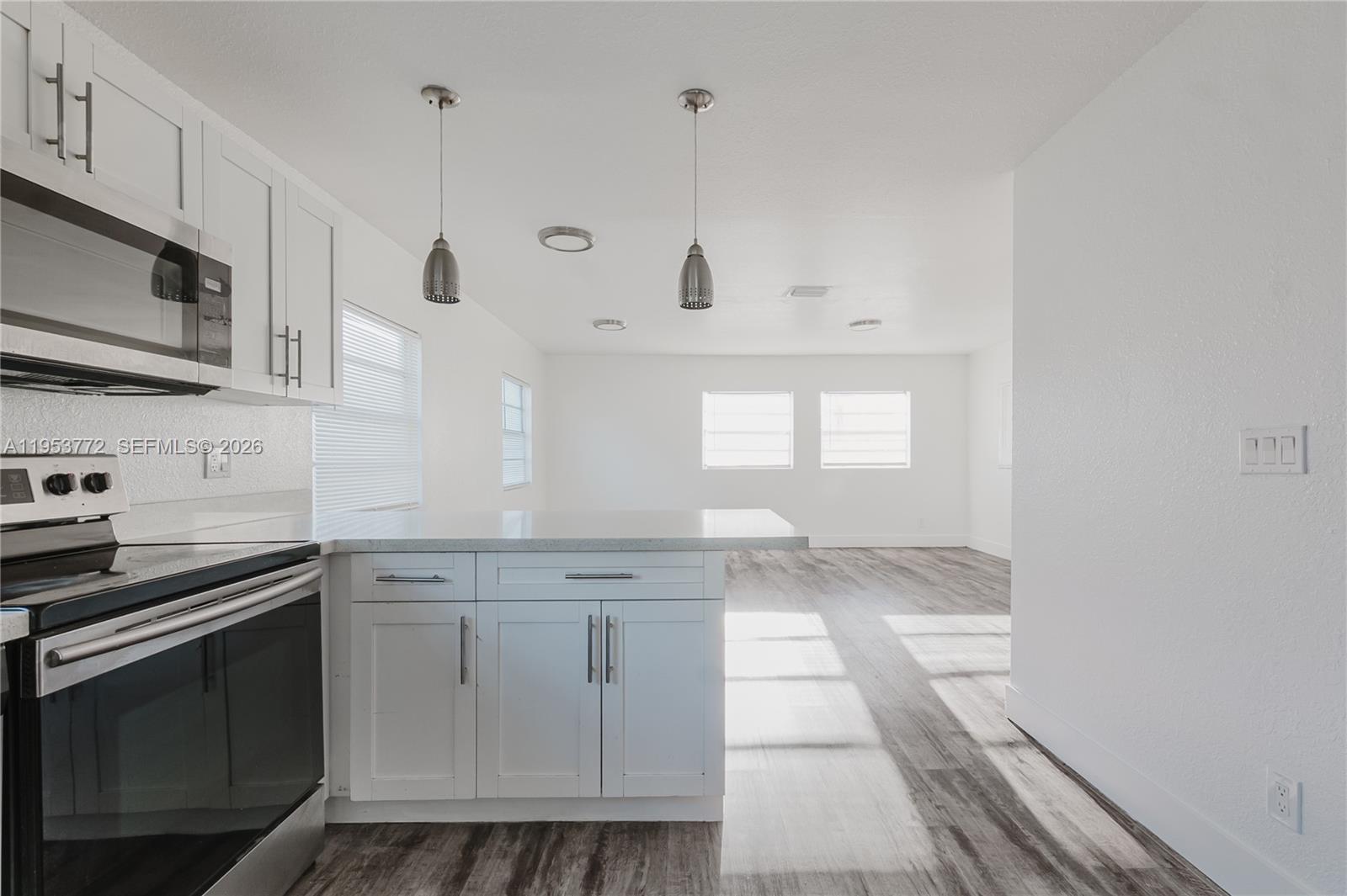 4338 Northwest 24th Avenue Miami, FL 33142 - Photo 8 of 26 a kitchen with granite countertop white cabinets and stainless steel appliances