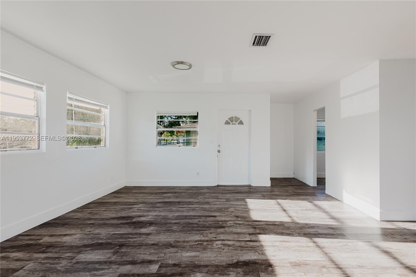 4338 Northwest 24th Avenue Miami, FL 33142 - Photo 9 of 26 a view of an empty room with wooden floor and a window