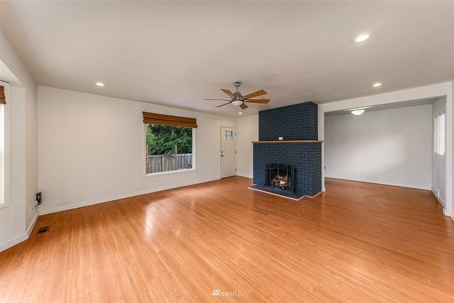 a view of a room a fireplace and wooden floor