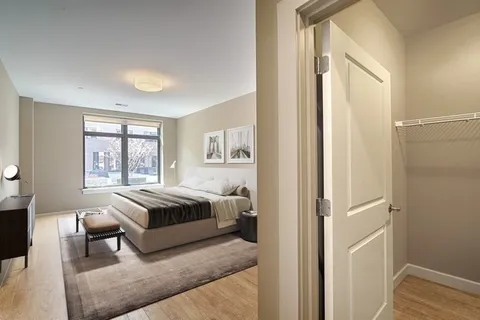 a spacious bedroom with a bed and wooden floor