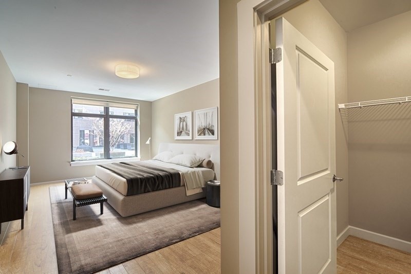 33 Rogers Street, Unit T27 Cambridge, MA 02142 - Photo 8 of 12 a spacious bedroom with a bed and wooden floor