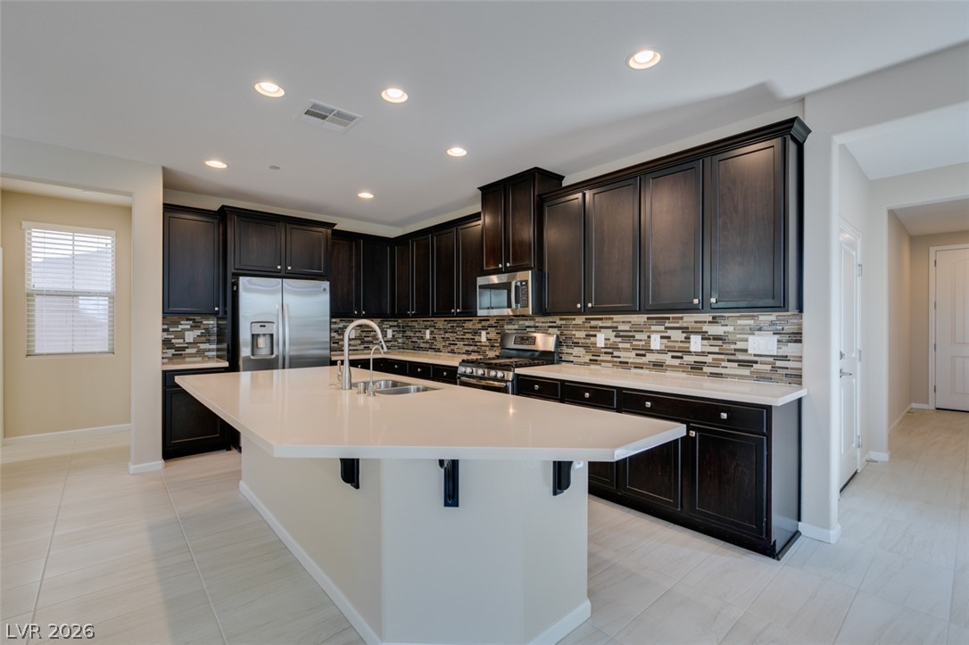 2549 Sable Ridge Street Henderson, NV 89044 - Photo 27 of 48 Culinary delights await in this sleek kitchen featuring a generous island and modern appliances.