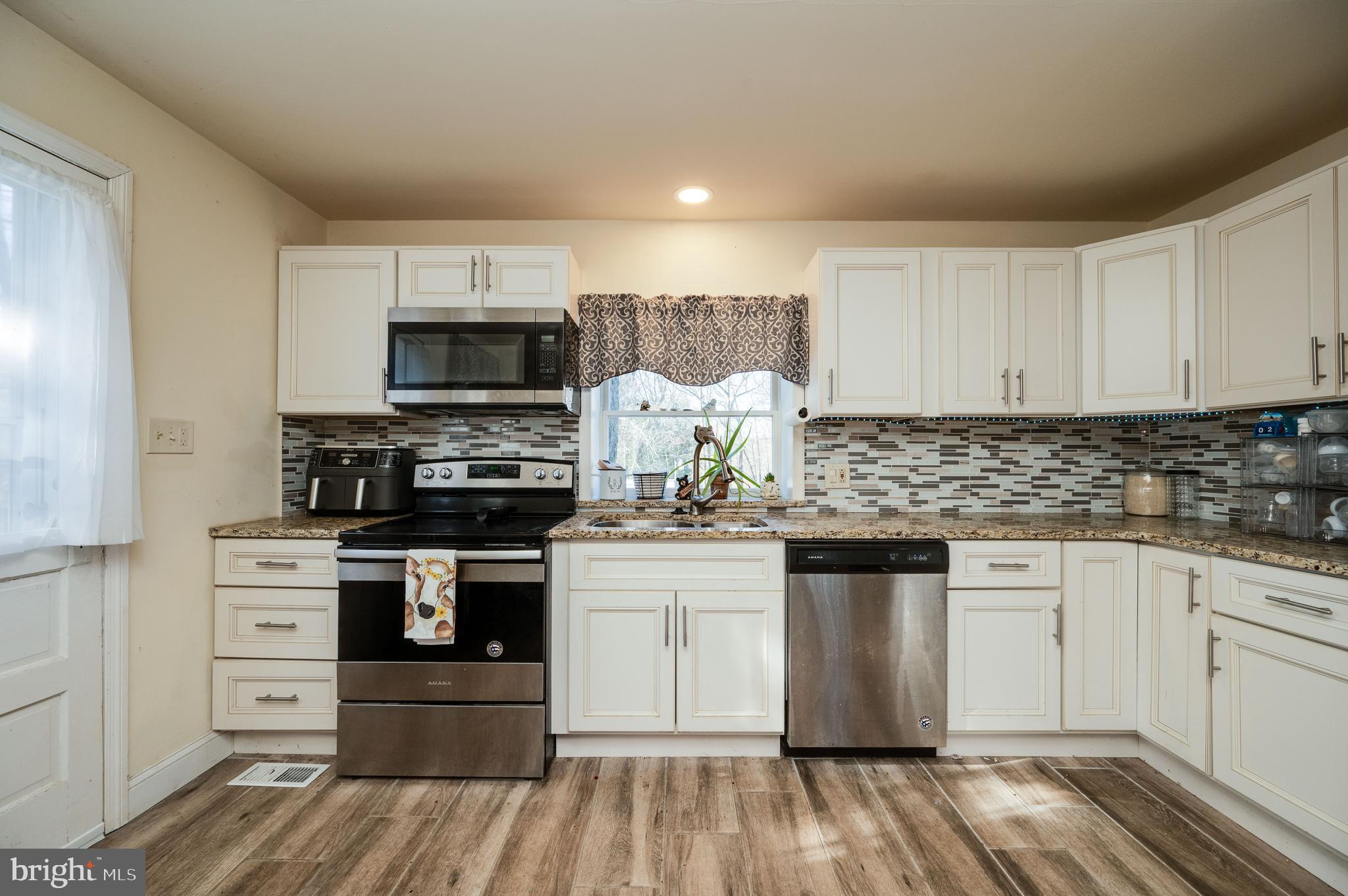 175 Forgedale Road Fleetwood, PA 19522 - Photo 10 of 42 a kitchen with stainless steel appliances granite countertop a stove top oven a sink dishwasher and a microwave oven with cabinets