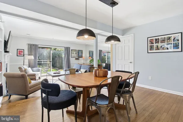 a dining room with furniture a chandelier and wooden floor