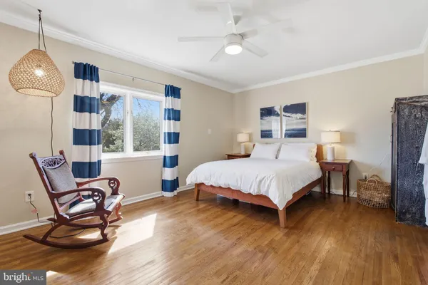 a bedroom with a bed a chair and a chandelier