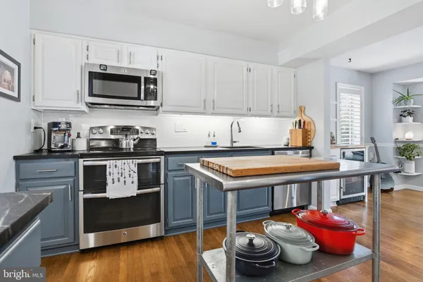 a kitchen with kitchen island granite countertop a sink and a stove top oven