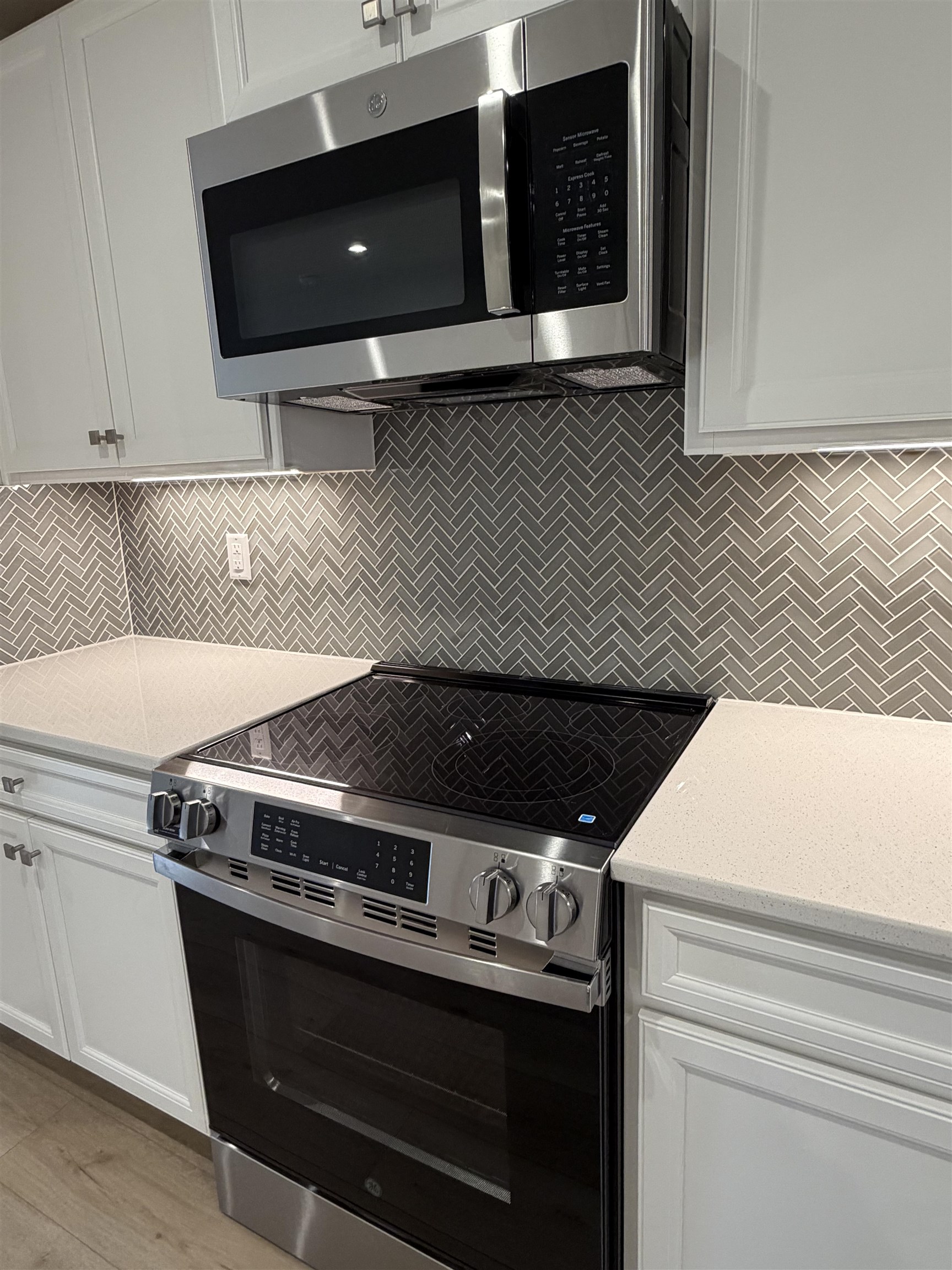 1303 Pleasant View Drive, Unit B North Myrtle Beach, SC 29582 - Photo 4 of 13 Kitchen featuring appliances with stainless steel finishes, white cabinetry, light stone counters, and tasteful backsplash