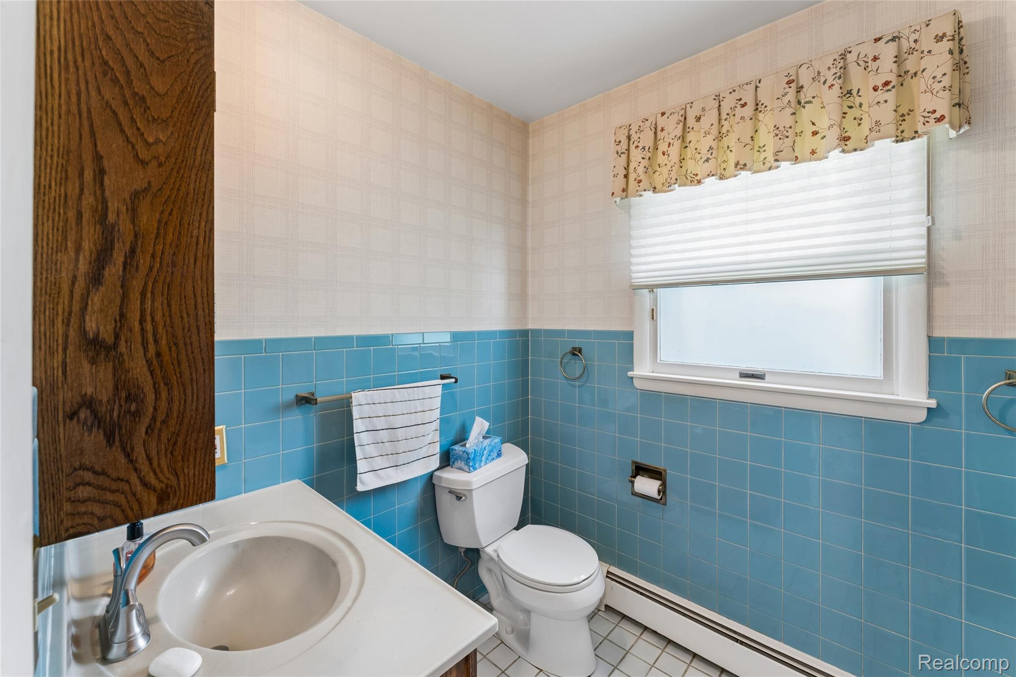 422 East Road Holly, MI 48442 - Photo 35 of 51 Bathroom with light blue tiled wainscoting and white grid-patterned wallpaper