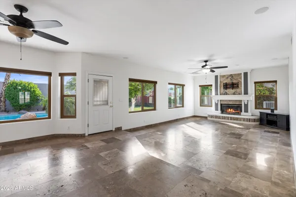 an empty room with a window and a chandelier fan