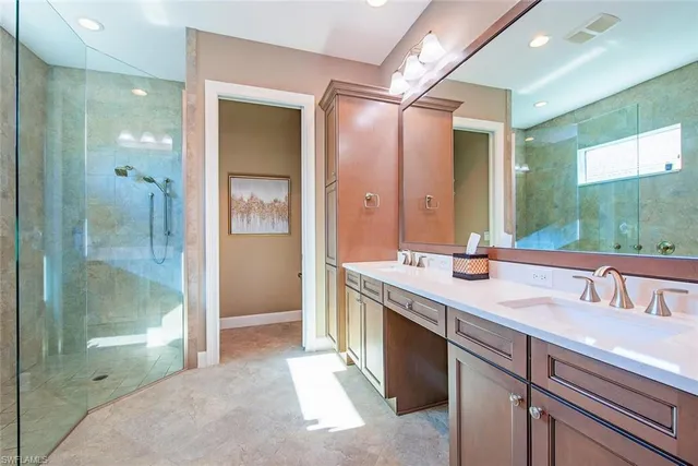 a spacious bathroom with a shower sink and mirror