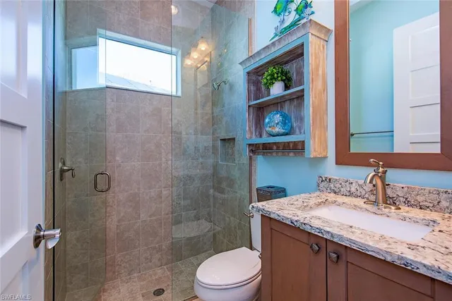 a bathroom with a granite countertop sink toilet and shower