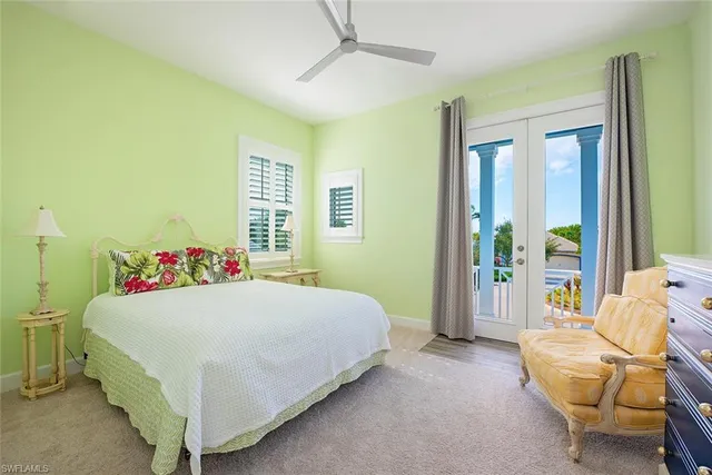 a bedroom with a bed and large windows