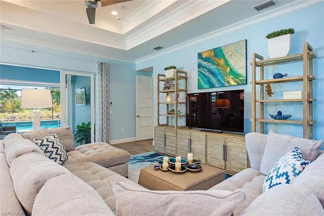 a living room with furniture kitchen view and a large window