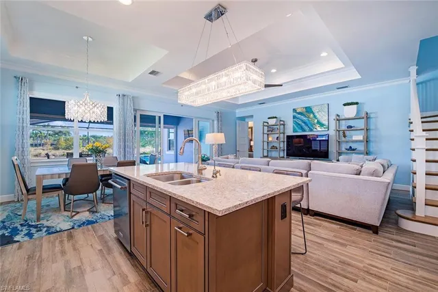 a open kitchen with stainless steel appliances granite countertop a kitchen island a stove and a living room view