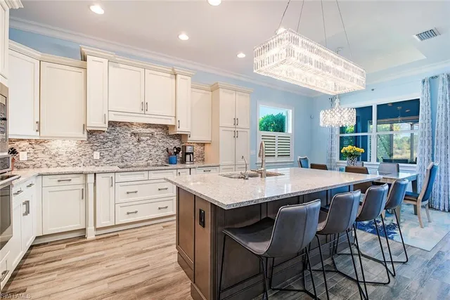 a kitchen with cabinets appliances and a large window