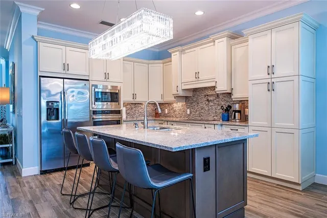 a kitchen with stainless steel appliances granite countertop a sink a refrigerator and a stove