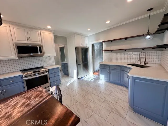 a kitchen with stainless steel appliances granite countertop a stove refrigerator and microwave