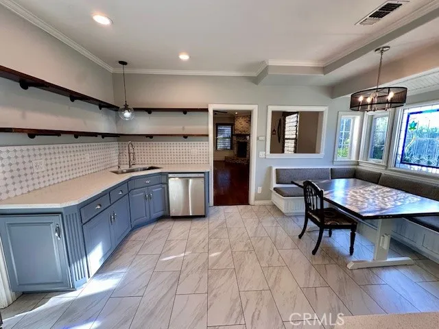 a kitchen with stainless steel appliances granite countertop a sink dishwasher a stove a refrigerator a dining table and chairs with wooden floor