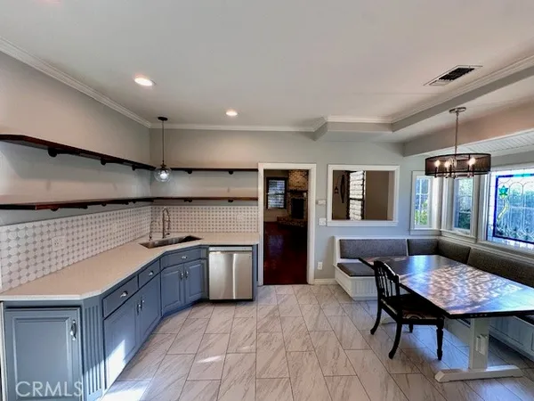 a large kitchen with stainless steel appliances kitchen island granite countertop a table chairs in it and a large window
