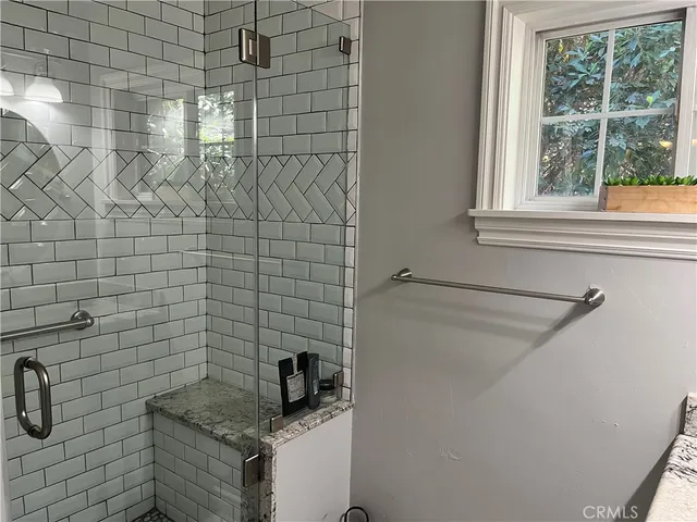 a bathroom with a granite countertop sink and a window