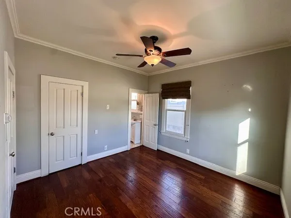 a view of an empty room with window and wooden floor
