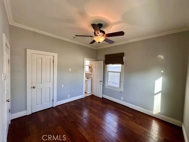 a view of an empty room with window and wooden floor